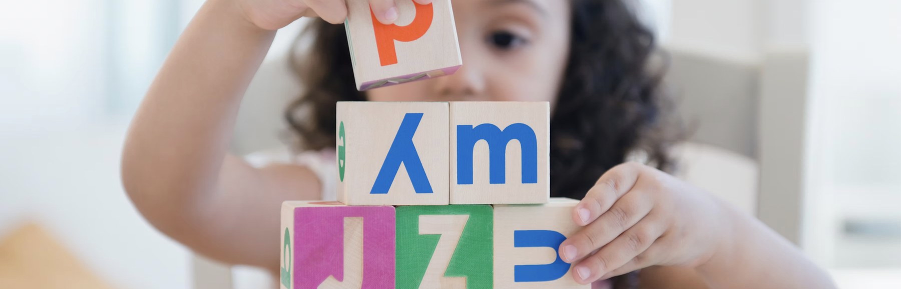Child using alphabet blocks during a language and literacy activity