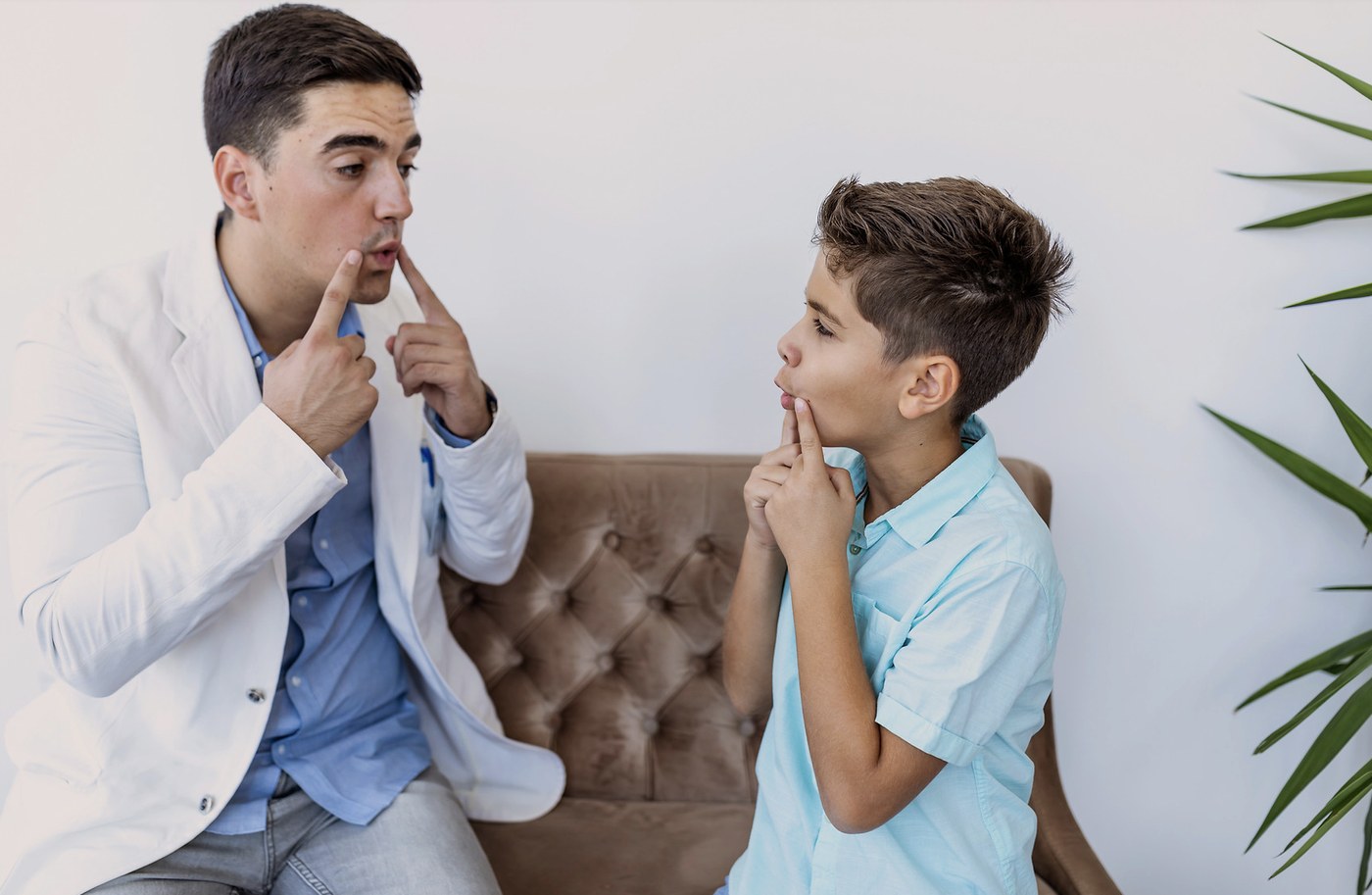 Speech pathologist supporting a child during speech sound practice